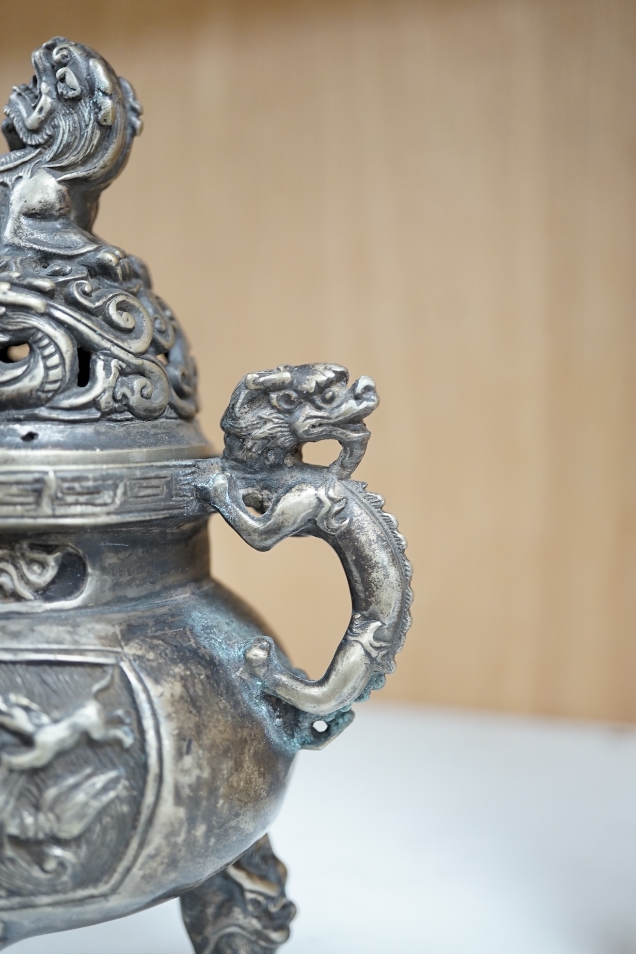 A Chinese silvered bronze lidded ‘dragon’ censer, 16cm tall. Condition - fair to good